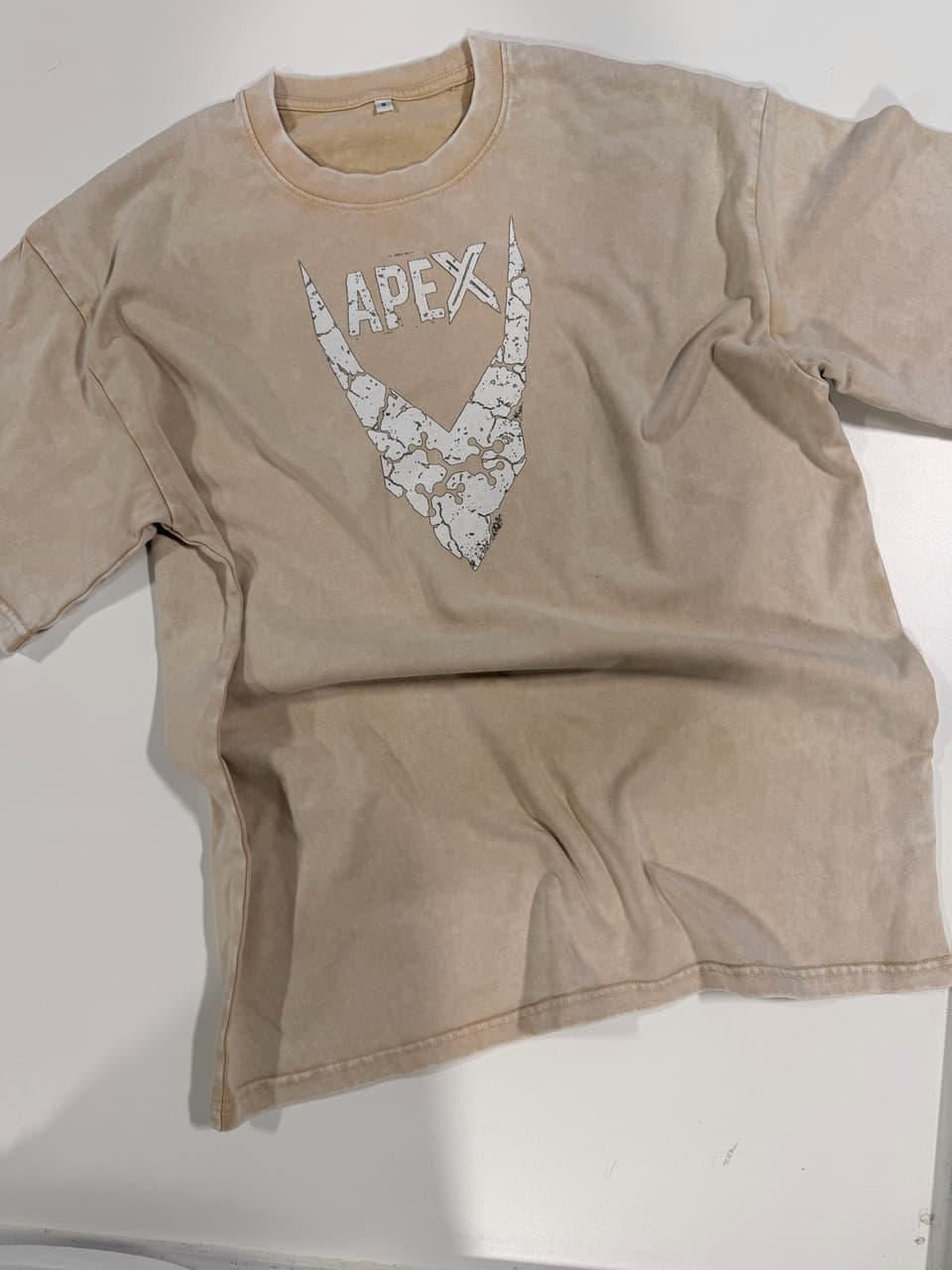 Sand-colored acid-wash T-shirt with a distressed white Apex logo